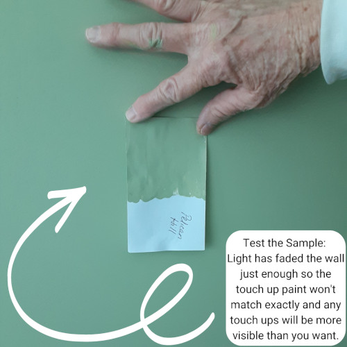 A hand holding a color swatch of paint to
                    determine if the swatch matches the existing paint.